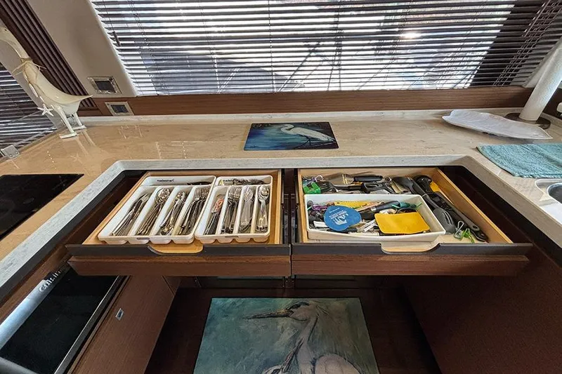 Slide: The Image of Kitchen drawers in 2015 Sea Ray 510 Fly yacht, featuring organized cutlery and tools. - 28