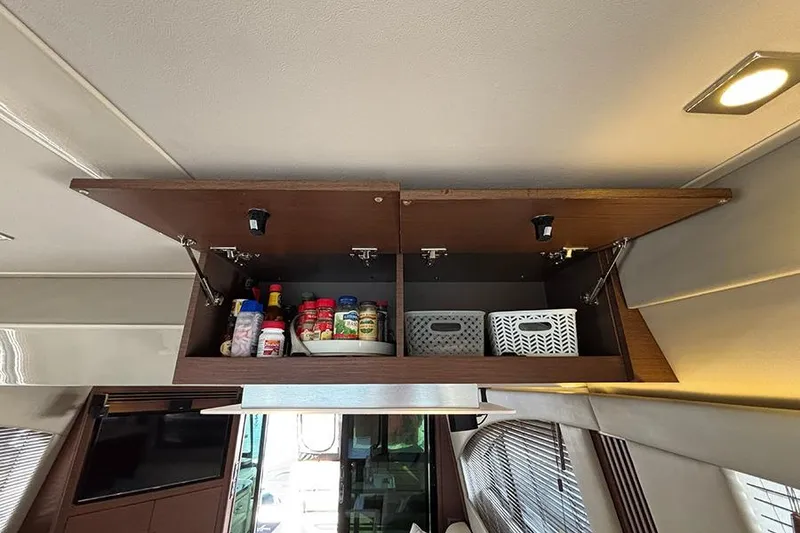 Slide: The Image of Open cabinet in 2015 Sea Ray 510 Fly yacht, storing spices and baskets. - 30