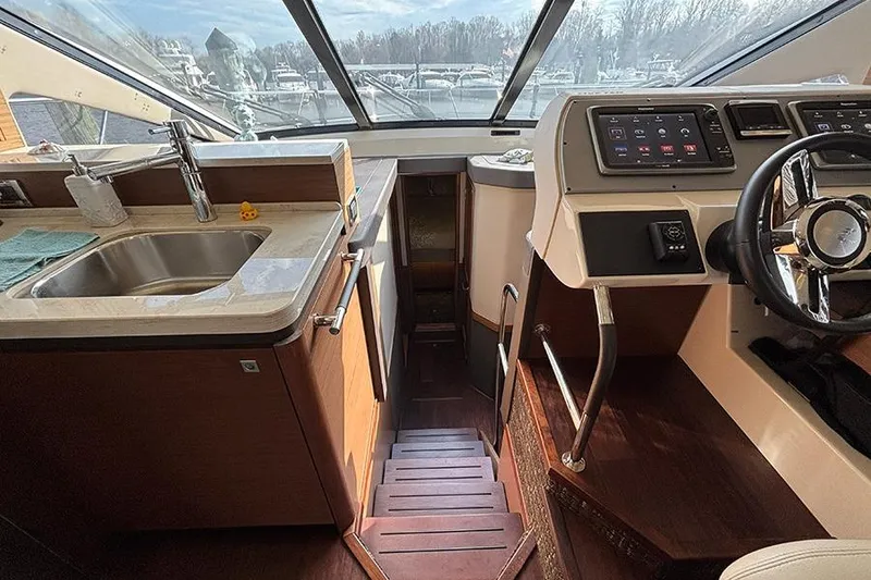 Slide: The Image of Interior of 2015 Sea Ray 510 Fly yacht with helm, sink, and stairs. - 31