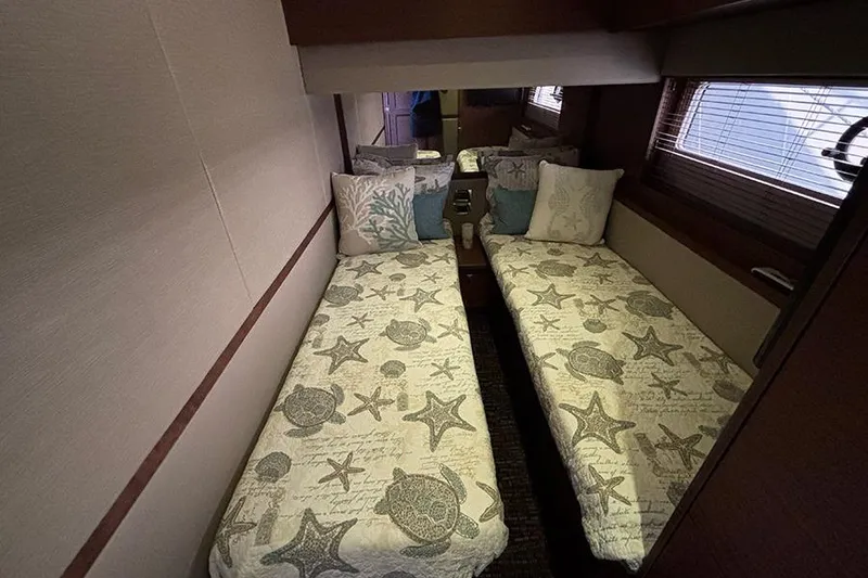 Slide: The Image of 2015 Sea Ray 510 Fly cabin with twin beds and nautical-themed bedding. - 40