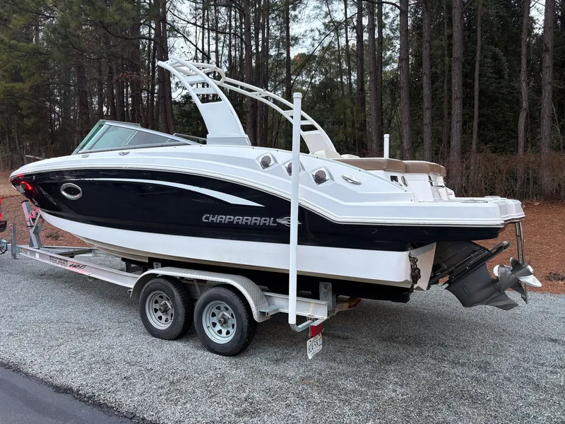 Slide: The Image of 2018 Chaparral 246 SSi boat on trailer in wooded area. - 3