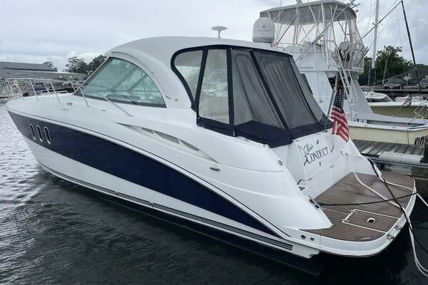 The Image of 2008 Cruisers Yachts 390 Express Coupe docked, featuring sleek design and American flag. - 0