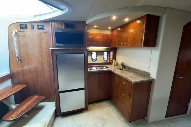 Slide: The Image of Luxurious 2008 Cruisers Yachts 390 Express Coupe interior kitchen with wood cabinetry and modern appliances. - 46