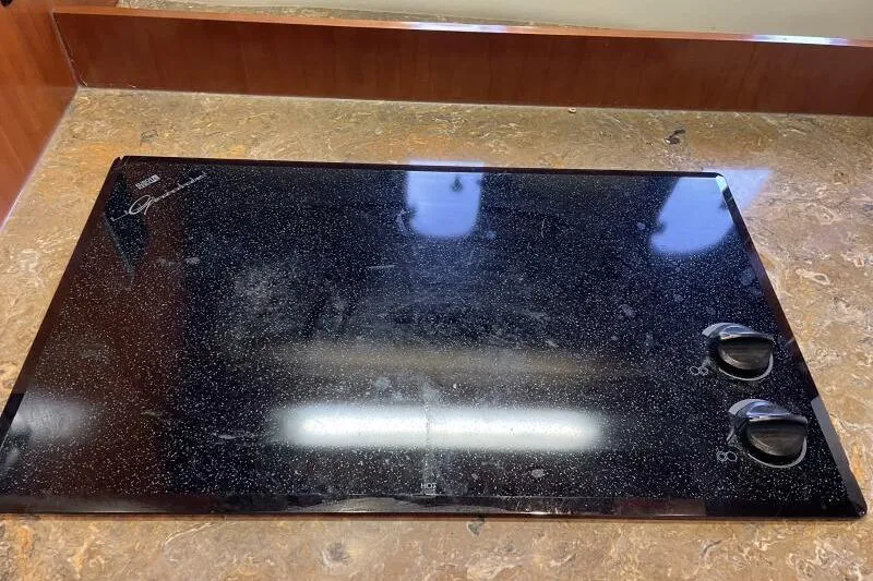 Slide: The Image of Stovetop on 2008 Cruisers Yachts 390 Express Coupe, featuring two control knobs. - 48