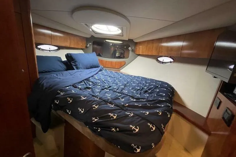Slide: The Image of Luxurious cabin interior of 2008 Cruisers Yachts 390 Express Coupe with nautical-themed bedding. - 50