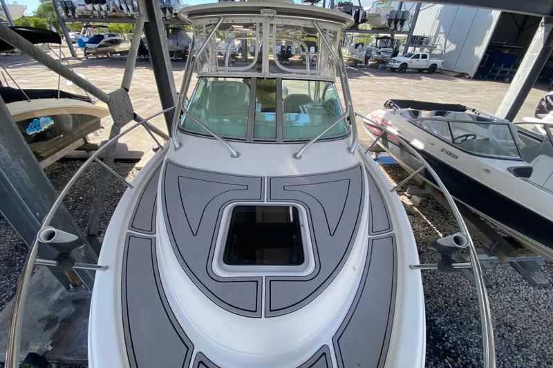 Slide: The Image of 2007 Robalo R265 Walkaround boat with sleek deck design in a marina setting. - 15