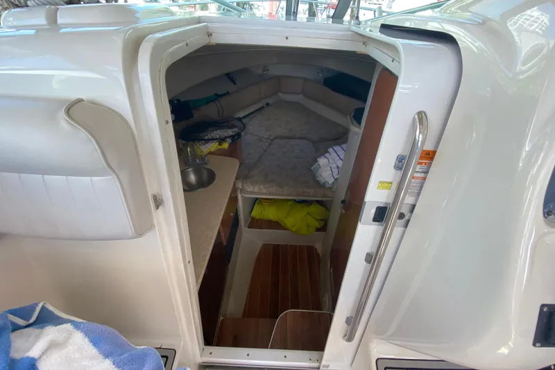 Slide: The Image of 2007 Robalo R265 Walkaround cabin interior with bed and kitchenette. - 29