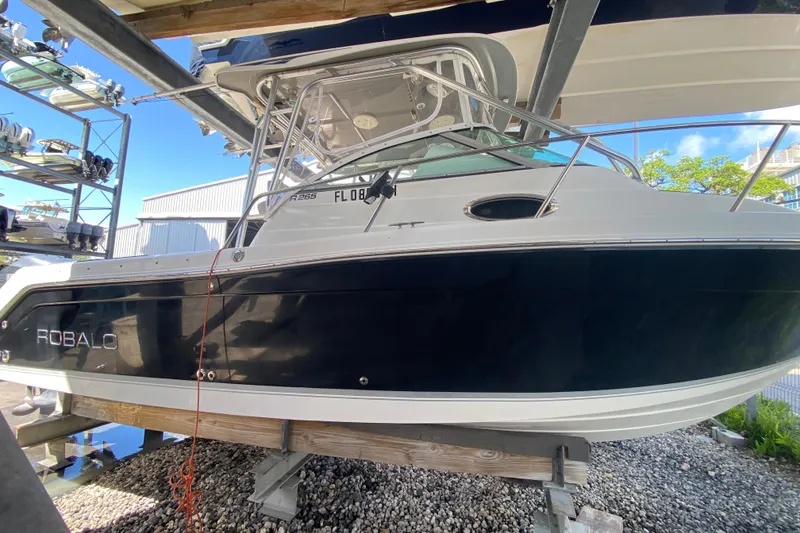 Slide: The Image of 2007 Robalo R265 Walkaround boat on a lift, showcasing sleek design and sturdy build. - 3