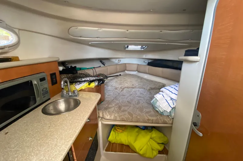 Slide: The Image of 2007 Robalo R265 Walkaround cabin interior with kitchenette and sleeping area. - 30