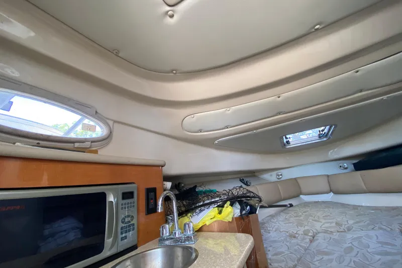 Slide: The Image of 2007 Robalo R265 Walkaround cabin interior with microwave, sink, and seating area. - 31