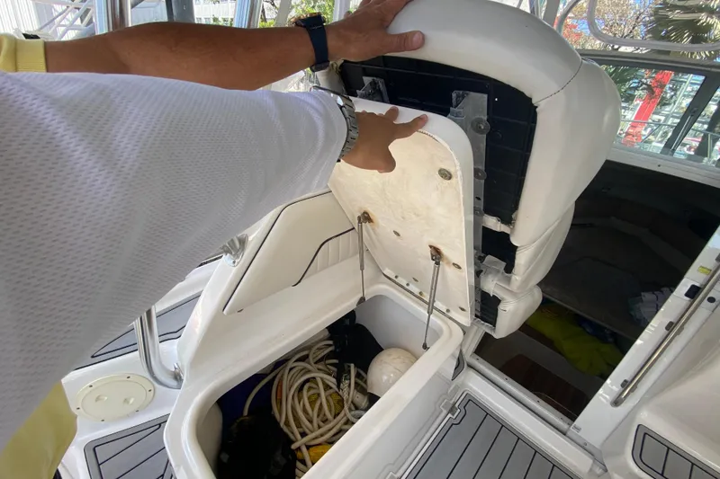 Slide: The Image of 2007 Robalo R265 Walkaround boat storage compartment with open seat revealing ropes and equipment. - 41