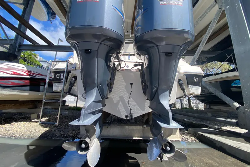 Slide: The Image of 2007 Robalo R265 Walkaround with twin outboard engines in a boatyard. - 46