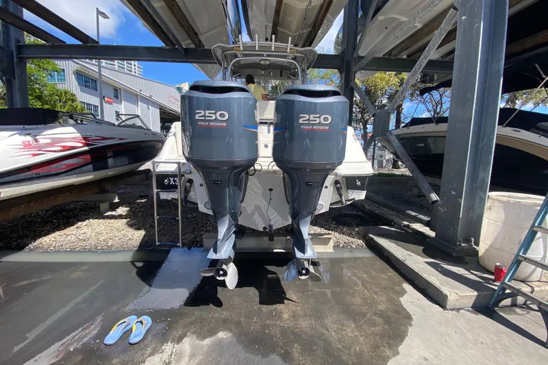 Slide: The Image of 2007 Robalo R265 Walkaround with twin 250 horsepower outboard engines in a boatyard. - 48