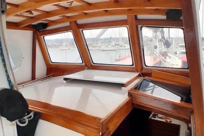 Slide: The Image of 1974 Force Hudson 50 boat interior with wooden trim and marina view. - 11