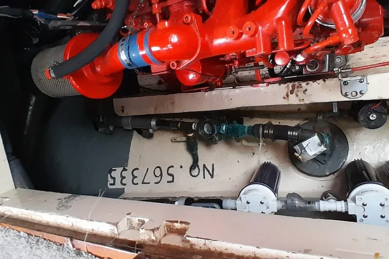 Slide: The Image of 1974 Force Hudson 50 engine compartment with red engine components and visible serial number. - 12