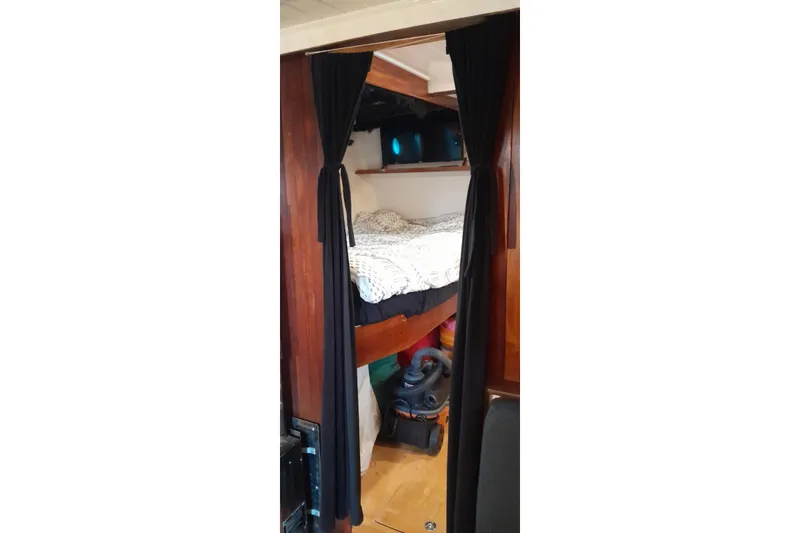 Slide: The Image of 1974 Force Hudson 50 interior with cozy bunk bed and dark curtains. - 17