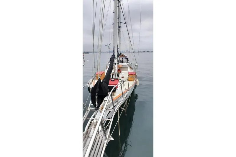 Slide: The Image of 1974 Force Hudson 50 sailboat docked on calm water under cloudy skies. - 18