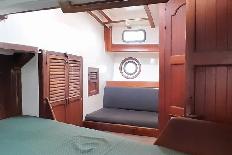 Slide: The Image of 1974 Force Hudson 50 yacht interior with wooden furnishings and porthole window. - 23