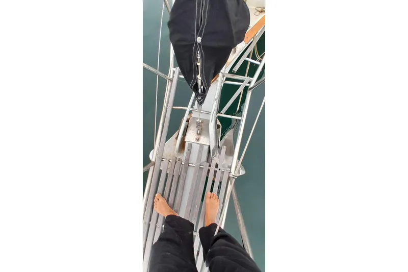 Slide: The Image of Barefoot person standing on a 1974 Force Hudson 50 sailboat deck, overlooking the water. - 24