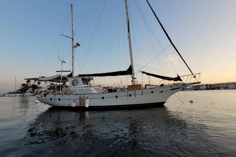 Slide: The Image of 1974 Force Hudson 50 sailboat anchored at sunset in a tranquil marina. - 26