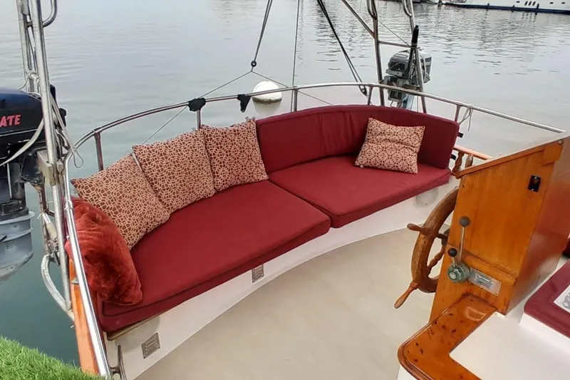 Slide: The Image of Luxurious seating area on 1974 Force Hudson 50 boat with red cushions and wooden steering wheel. - 32