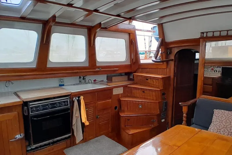 Slide: The Image of 1974 Force Hudson 50 yacht interior with wooden cabinetry, kitchen, and seating area. - 35