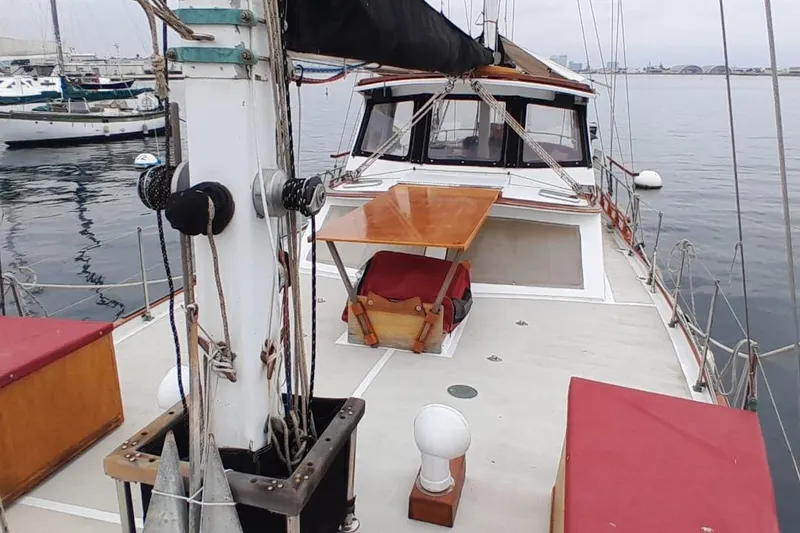 Slide: The Image of 1974 Force Hudson 50 sailboat deck with mast and cabin, docked in a marina. - 38