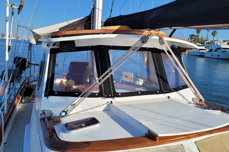 Slide: The Image of 1974 Force Hudson 50 sailboat docked, featuring a sleek cabin and clear blue waters. - 4
