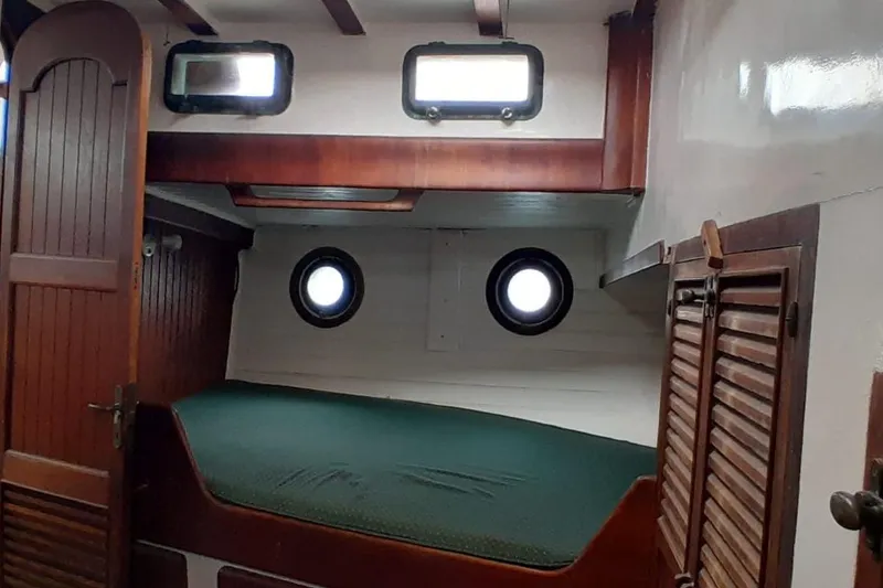 Slide: The Image of 1974 Force Hudson 50 cabin interior with wooden accents and porthole windows. - 42