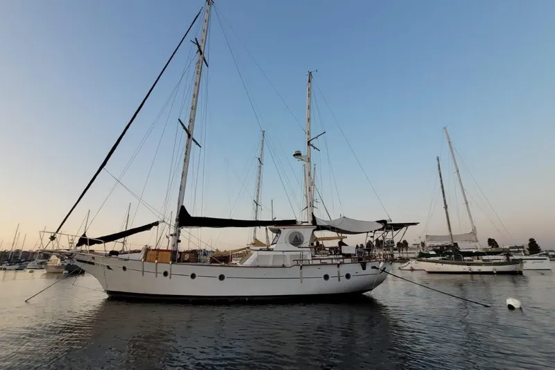 Slide: The Image of 1974 Force Hudson 50 sailboat anchored in calm waters at sunset. - 45