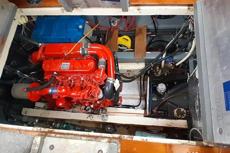 Slide: The Image of Engine compartment of a 1974 Force Hudson 50, featuring a red engine and various components. - 47