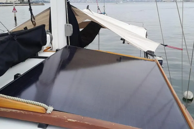 Slide: The Image of Solar panel on 1974 Force Hudson 50 sailboat deck, docked by calm waters. - 49