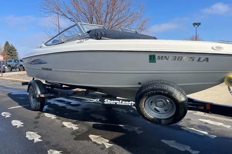Slide: The Image of 2013 Stingray 191 RX boat on trailer, parked outdoors on a sunny day. - 3