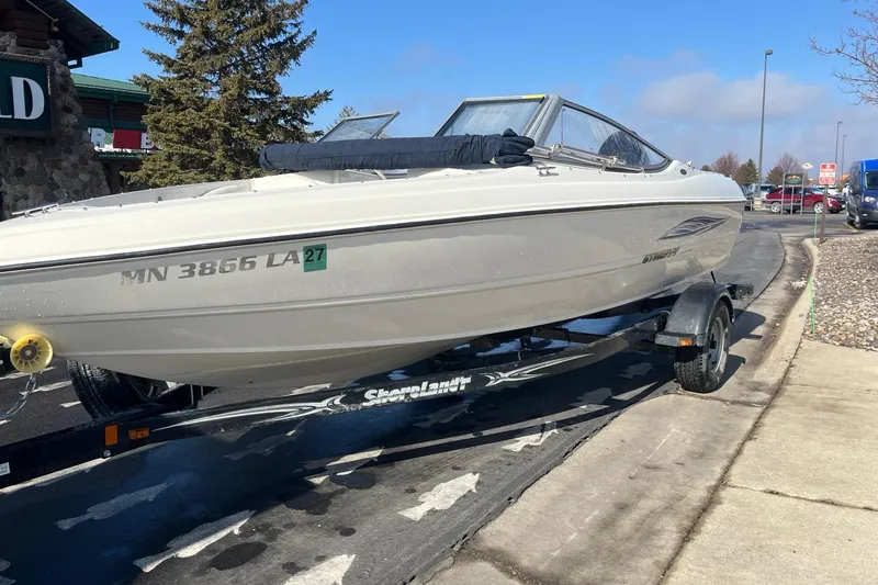 Slide: The Image of 2013 Stingray 191 RX boat on trailer, parked outdoors near a building. - 4