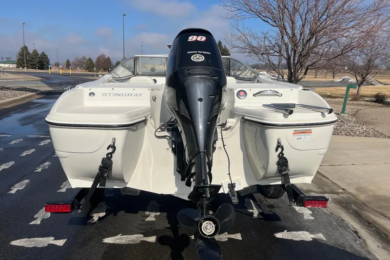 Slide: The Image of 2013 Stingray 191 RX boat with outboard motor, parked on a sunny day. - 5