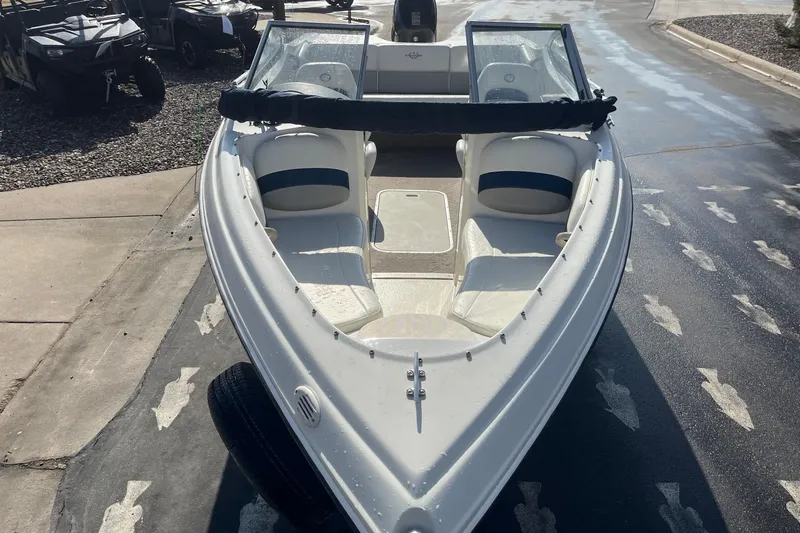 Slide: The Image of 2013 Stingray 191 RX boat, white interior, parked on wet pavement. - 6