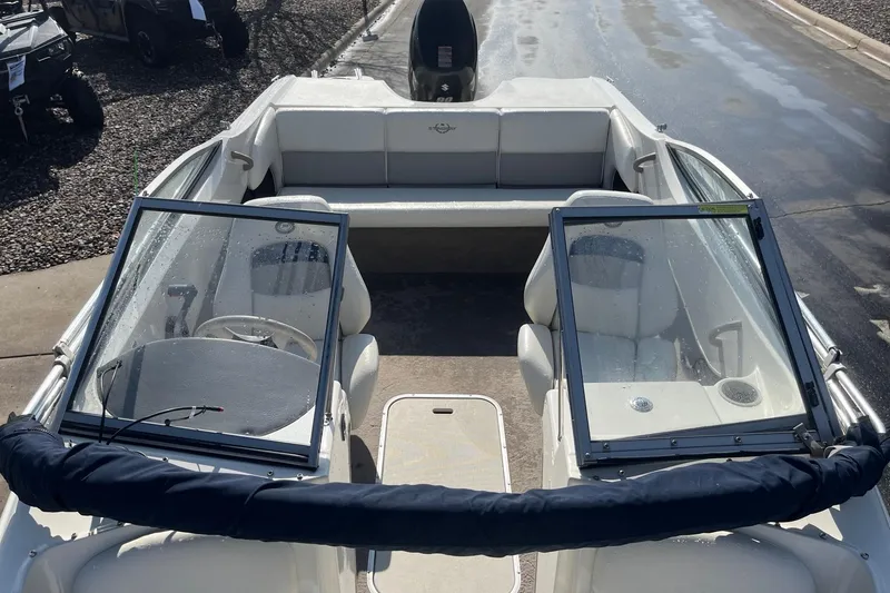 Slide: The Image of 2013 Stingray 191 RX boat interior with seating and windshield, parked on a wet surface. - 7