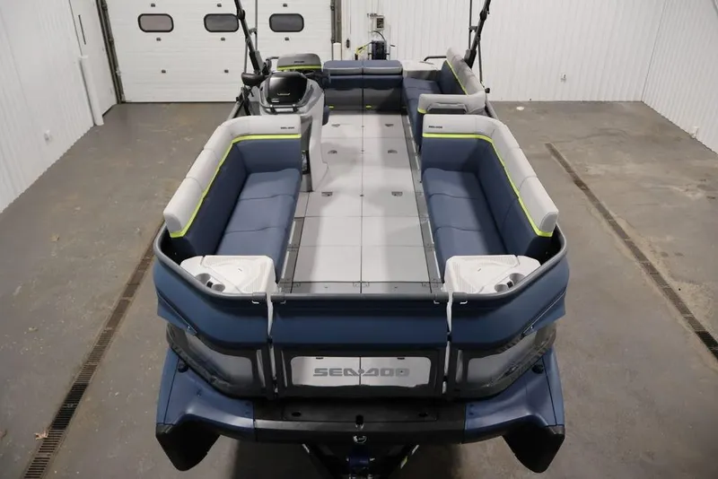 Slide: The Image of 2025 Sea-Doo Switch Cruise 21 pontoon boat with spacious seating in a garage setting. - 10