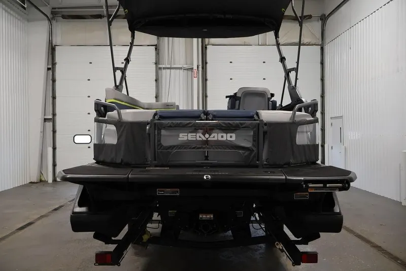 Slide: The Image of 2025 Sea-Doo Switch Cruise 21 pontoon boat in a garage, rear view. - 7