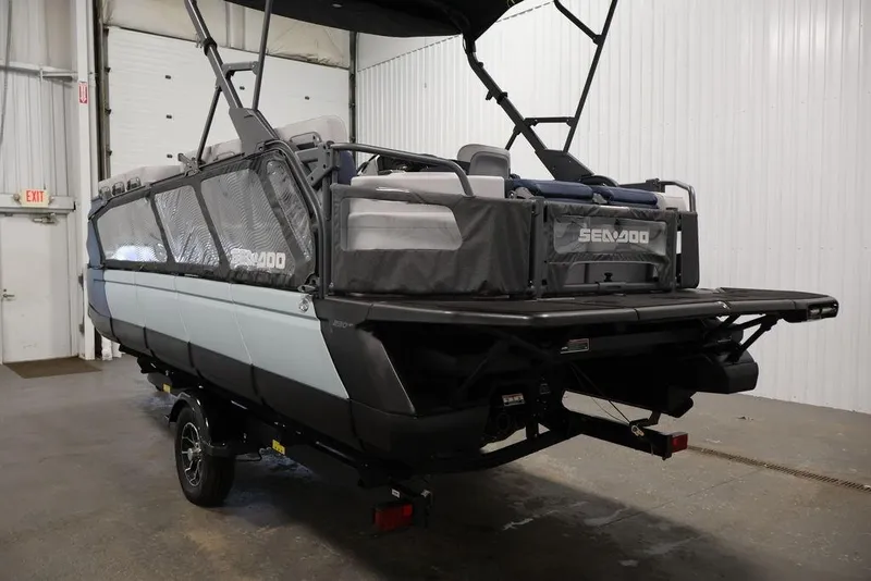 Slide: The Image of 2025 Sea-Doo Switch Cruise 21 pontoon boat in a warehouse setting. - 8