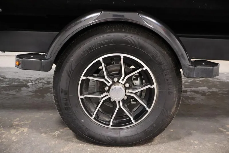 Slide: The Image of Trailer wheel of 2025 Sea-Doo Switch Cruise 21, featuring black alloy rim design. - 28