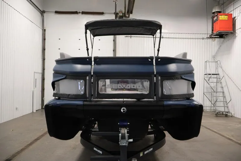 Slide: The Image of 2025 Sea-Doo Switch Cruise 21 pontoon boat in a garage, rear view. - 5