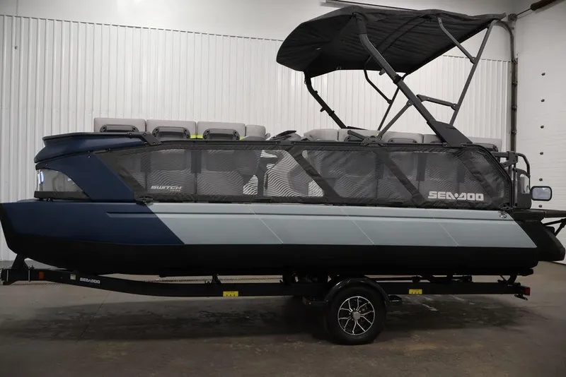 Slide: The Image of 2025 Sea-Doo Switch Cruise 21 pontoon boat in a showroom setting. - 6