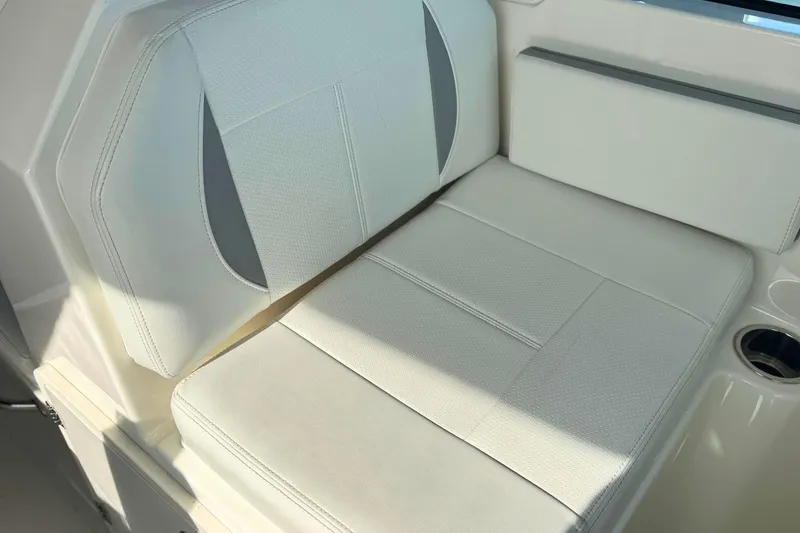 Slide: The Image of 2023 Pursuit DC 266 Dual Console boat seat with white upholstery and cup holder. - 16
