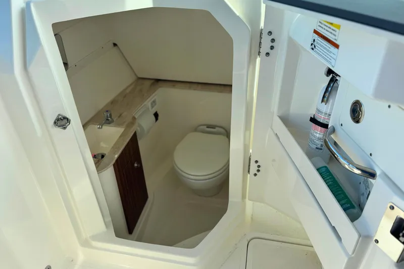 Slide: The Image of 2023 Pursuit DC 266 Dual Console boat interior with compact bathroom amenities. - 18
