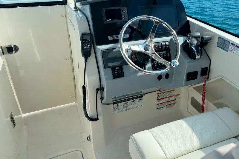 Slide: The Image of 2023 Pursuit DC 266 Dual Console boat helm with steering wheel and controls. - 19