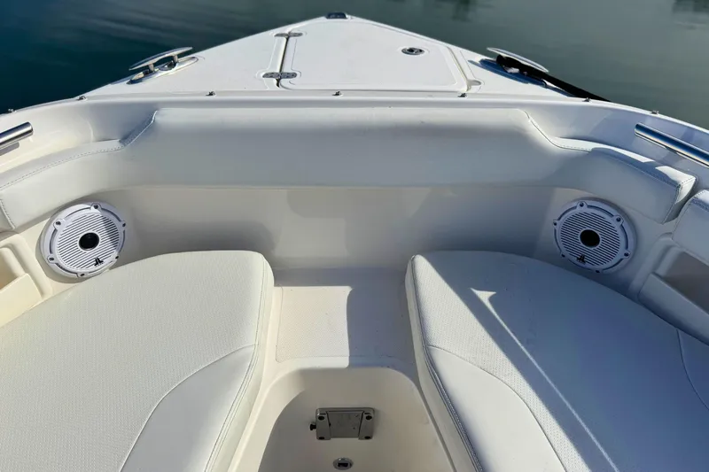 Slide: The Image of 2023 Pursuit DC 266 Dual Console boat interior with white seating and speakers. - 23