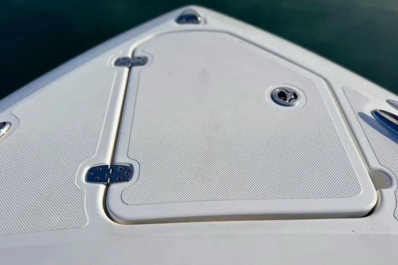 Slide: The Image of 2023 Pursuit DC 266 Dual Console boat deck with hatch and hinges. - 28