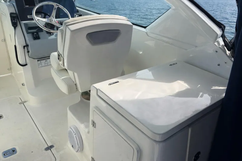 Slide: The Image of 2023 Pursuit DC 266 Dual Console interior with steering wheel and seating, overlooking water. - 7