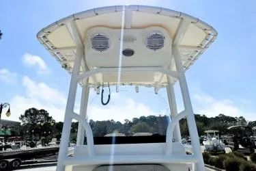 Slide: The Image of 2023 Sea Pro 219 Center Console boat with T-top and speakers, docked under blue sky. - 6